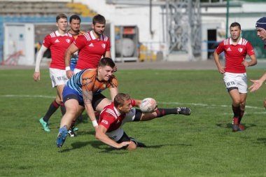 ODESSA, UKRAINE - SEPT 20, 2017: CREDO-Odessa Rugby Şampiyonası Milli Takımı - Politeknik-Kiev. Rugby oyuncularının top için yoğun mücadelesi. Stadyumun yeşil sahasında dinamik oyun