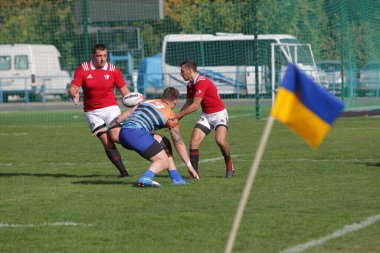 ODESSA, UKRAINE - SEPT 20, 2017: CREDO-Odessa Rugby Şampiyonası Milli Takımı - Politeknik-Kiev. Rugby oyuncularının top için yoğun mücadelesi. Stadyumun yeşil sahasında dinamik oyun