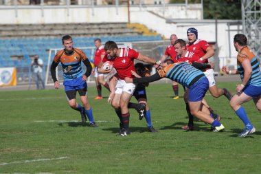 ODESSA, UKRAINE - SEPT 20, 2017: CREDO-Odessa Rugby Şampiyonası Milli Takımı - Politeknik-Kiev. Rugby oyuncularının top için yoğun mücadelesi. Stadyumun yeşil sahasında dinamik oyun
