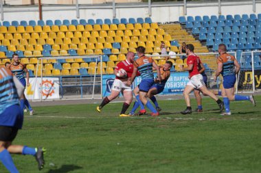 ODESSA, UKRAINE - SEPT 20, 2017: CREDO-Odessa Rugby Şampiyonası Milli Takımı - Politeknik-Kiev. Rugby oyuncularının top için yoğun mücadelesi. Stadyumun yeşil sahasında dinamik oyun