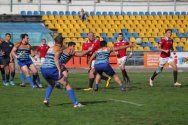 ODESSA, UKRAINE - SEPT 20, 2017: CREDO-Odessa Rugby Şampiyonası Milli Takımı - Politeknik-Kiev. Rugby oyuncularının top için yoğun mücadelesi. Stadyumun yeşil sahasında dinamik oyun