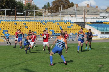 ODESSA, UKRAINE - SEPT 20, 2017: CREDO-Odessa Rugby Şampiyonası Milli Takımı - Politeknik-Kiev. Rugby oyuncularının top için yoğun mücadelesi. Stadyumun yeşil sahasında dinamik oyun