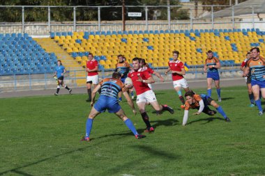 ODESSA, UKRAINE - SEPT 20, 2017: CREDO-Odessa Rugby Şampiyonası Milli Takımı - Politeknik-Kiev. Rugby oyuncularının top için yoğun mücadelesi. Stadyumun yeşil sahasında dinamik oyun