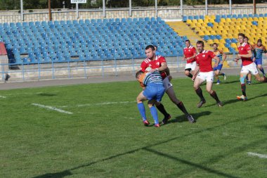 ODESSA, UKRAINE - SEPT 20, 2017: CREDO-Odessa Rugby Şampiyonası Milli Takımı - Politeknik-Kiev. Rugby oyuncularının top için yoğun mücadelesi. Stadyumun yeşil sahasında dinamik oyun