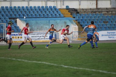 ODESSA, UKRAINE - SEPT 20, 2017: CREDO-Odessa Rugby Şampiyonası Milli Takımı - Politeknik-Kiev. Rugby oyuncularının top için yoğun mücadelesi. Stadyumun yeşil sahasında dinamik oyun