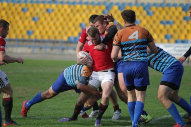 ODESSA, UKRAINE - SEPT 20, 2017: CREDO-Odessa Rugby Şampiyonası Milli Takımı - Politeknik-Kiev. Rugby oyuncularının top için yoğun mücadelesi. Stadyumun yeşil sahasında dinamik oyun