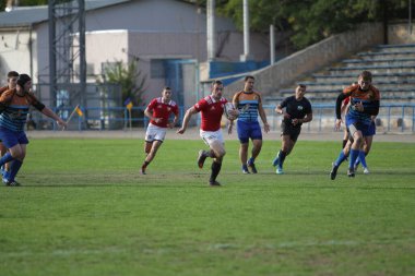 ODESSA, UKRAINE - SEPT 20, 2017: CREDO-Odessa Rugby Şampiyonası Milli Takımı - Politeknik-Kiev. Rugby oyuncularının top için yoğun mücadelesi. Stadyumun yeşil sahasında dinamik oyun