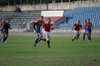 ODESSA, UKRAINE - SEPT 20, 2017: CREDO-Odessa Rugby Şampiyonası Milli Takımı - Politeknik-Kiev. Rugby oyuncularının top için yoğun mücadelesi. Stadyumun yeşil sahasında dinamik oyun
