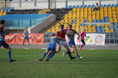 ODESSA, UKRAINE - SEPT 20, 2017: CREDO-Odessa Rugby Şampiyonası Milli Takımı - Politeknik-Kiev. Rugby oyuncularının top için yoğun mücadelesi. Stadyumun yeşil sahasında dinamik oyun