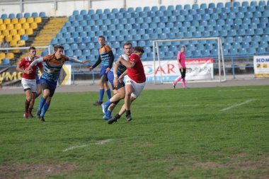 ODESSA, UKRAINE - SEPT 20, 2017: CREDO-Odessa Rugby Şampiyonası Milli Takımı - Politeknik-Kiev. Rugby oyuncularının top için yoğun mücadelesi. Stadyumun yeşil sahasında dinamik oyun