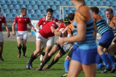 ODESSA, UKRAINE - SEPT 20, 2017: CREDO-Odessa Rugby Şampiyonası Milli Takımı - Politeknik-Kiev. Rugby oyuncularının top için yoğun mücadelesi. Stadyumun yeşil sahasında dinamik oyun