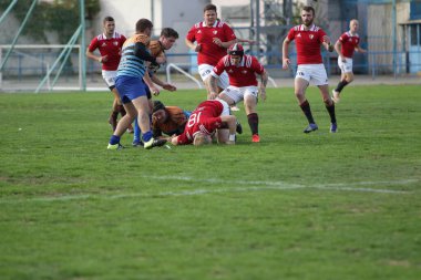 ODESSA, UKRAINE - SEPT 20, 2017: CREDO-Odessa Rugby Şampiyonası Milli Takımı - Politeknik-Kiev. Rugby oyuncularının top için yoğun mücadelesi. Stadyumun yeşil sahasında dinamik oyun