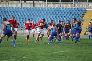 ODESSA, UKRAINE - SEPT 20, 2017: CREDO-Odessa Rugby Şampiyonası Milli Takımı - Politeknik-Kiev. Rugby oyuncularının top için yoğun mücadelesi. Stadyumun yeşil sahasında dinamik oyun