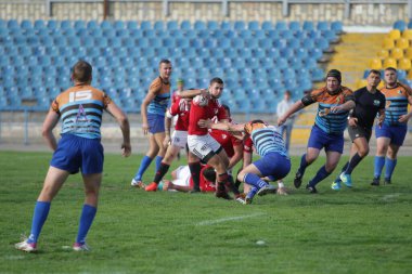 ODESSA, UKRAINE - SEPT 20, 2017: CREDO-Odessa Rugby Şampiyonası Milli Takımı - Politeknik-Kiev. Rugby oyuncularının top için yoğun mücadelesi. Stadyumun yeşil sahasında dinamik oyun