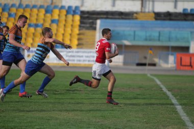 ODESSA, UKRAINE - SEPT 20, 2017: CREDO-Odessa Rugby Şampiyonası Milli Takımı - Politeknik-Kiev. Rugby oyuncularının top için yoğun mücadelesi. Stadyumun yeşil sahasında dinamik oyun