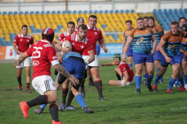 ODESSA, UKRAINE - SEPT 20, 2017: CREDO-Odessa Rugby Şampiyonası Milli Takımı - Politeknik-Kiev. Rugby oyuncularının top için yoğun mücadelesi. Stadyumun yeşil sahasında dinamik oyun