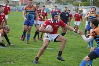 ODESSA, UKRAINE - SEPT 20, 2017: CREDO-Odessa Rugby Şampiyonası Milli Takımı - Politeknik-Kiev. Rugby oyuncularının top için yoğun mücadelesi. Stadyumun yeşil sahasında dinamik oyun