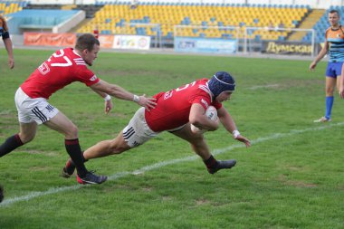 ODESSA, UKRAINE - SEPT 20, 2017: CREDO-Odessa Rugby Şampiyonası Milli Takımı - Politeknik-Kiev. Rugby oyuncularının top için yoğun mücadelesi. Stadyumun yeşil sahasında dinamik oyun