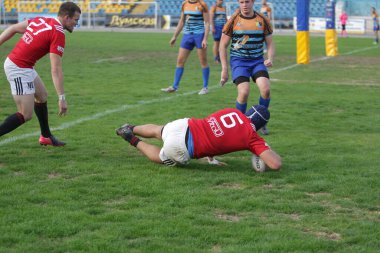 ODESSA, UKRAINE - SEPT 20, 2017: CREDO-Odessa Rugby Şampiyonası Milli Takımı - Politeknik-Kiev. Rugby oyuncularının top için yoğun mücadelesi. Stadyumun yeşil sahasında dinamik oyun