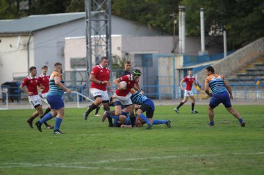 ODESSA, UKRAINE - SEPT 20, 2017: CREDO-Odessa Rugby Şampiyonası Milli Takımı - Politeknik-Kiev. Rugby oyuncularının top için yoğun mücadelesi. Stadyumun yeşil sahasında dinamik oyun