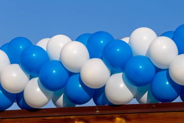 Mavi ve beyaz şişme balonların şenlikli arka planı. Şenlikli plastik hava şişirilebilir helyum balonları mavi doku arka planı.