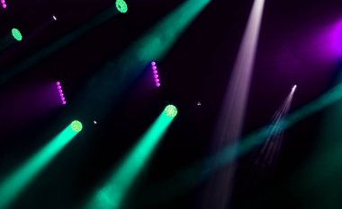 Sahne ışıkları. Gösterinin arka planı. Aydınlık spot ışıkları karanlıkta. Tiyatro sahnesinin içi projektöre aydınlatılmıştır. Konser sırasında sahne ışıkları ve sahne dumanı