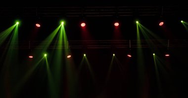 Sahne ışıkları. Gösterinin arka planı. Aydınlık spot ışıkları karanlıkta. Tiyatro sahnesinin içi projektöre aydınlatılmıştır. Konser sırasında sahne ışıkları ve sahne dumanı