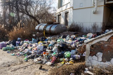Yasadışı ev çöplüğü. İnsanlar evlerinin çöplerini yasadışı çöplüklere atıyorlar. Terk edilmiş plastik çöp, plastik torbalar, şişeler. Ev atıklarının imhası ile ilgili çevre sorunu