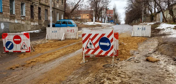 Renovation of the old road. Road Closed sign shows the direction of the detour road transport. Very bad road accident with wooden shields and arrows detour damaged pavement