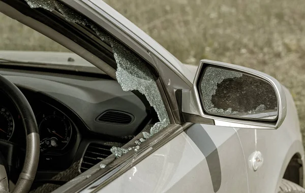 犯罪事件 偷了一辆汽车 汽车的侧窗坏了 窃贼用碎片砸碎车窗 玻璃散落各处 破窗行窃财物 — 图库照片