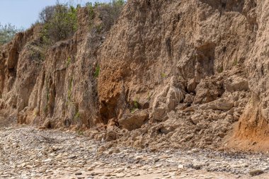 Karadeniz kıyısındaki heyelan bölgesi. Deniz taşı kabuğu. Yağmur mevsiminde doğal afetler bölgesi. Büyük toprak kütleleri tepenin yamacında kayıp evleri yok ediyor. Heyelan - yaşam tehdidi
