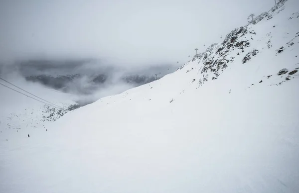 Weergave van een skipiste in bewolkt bergen — Stockfoto