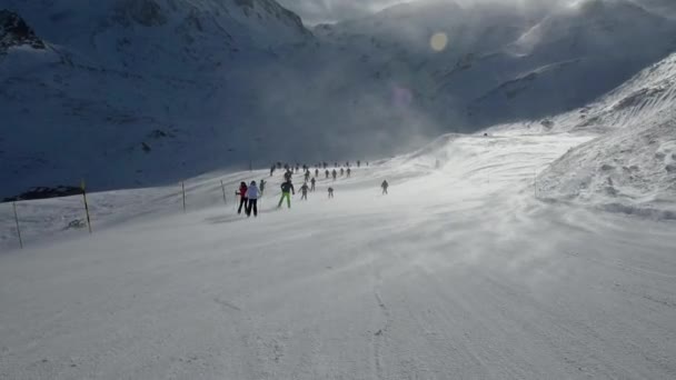 Esquiadores en pista bajando con fuertes vientos — Vídeo de stock