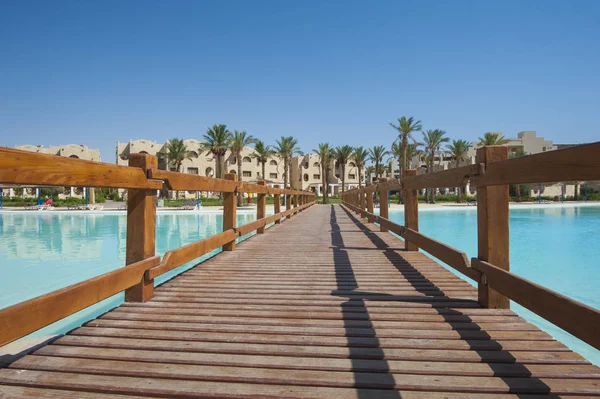 Large swimming pool with wooden bridge at luxury tropical hotel — Stock Photo, Image