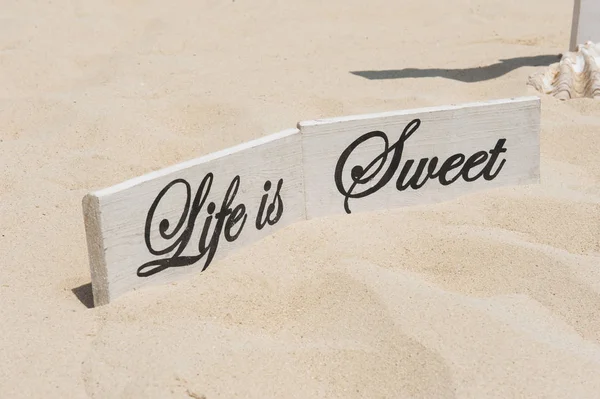 Wooden sign on tropical sandy beach — Stock Photo, Image