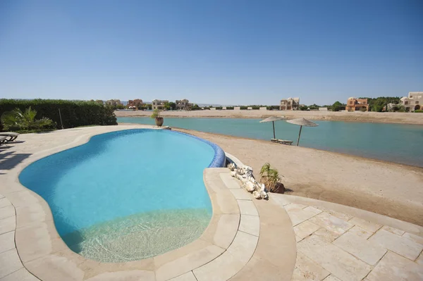 Piscina en una lujosa villa de vacaciones tropicales con playa —  Fotos de Stock