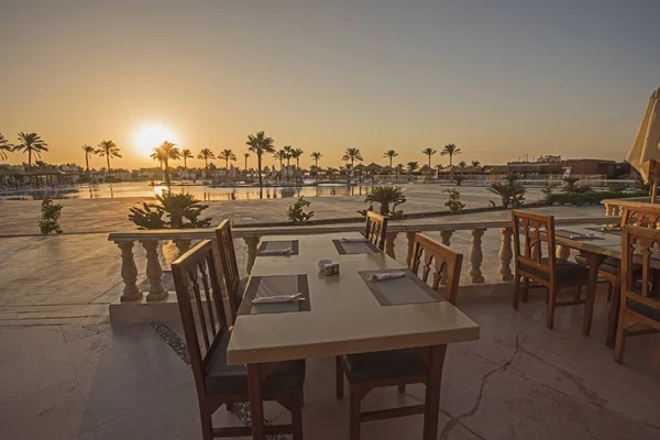 Обеденный стол на открытом воздухе с закатом в тропическом отеле — стоковое фото