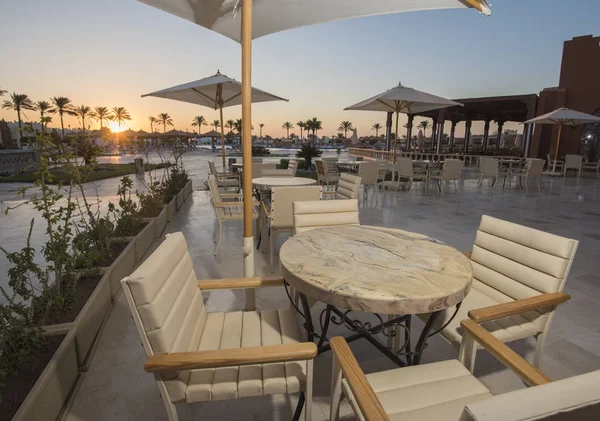 Área de terraza al aire libre con mesas en un complejo hotelero tropical en s —  Fotos de Stock