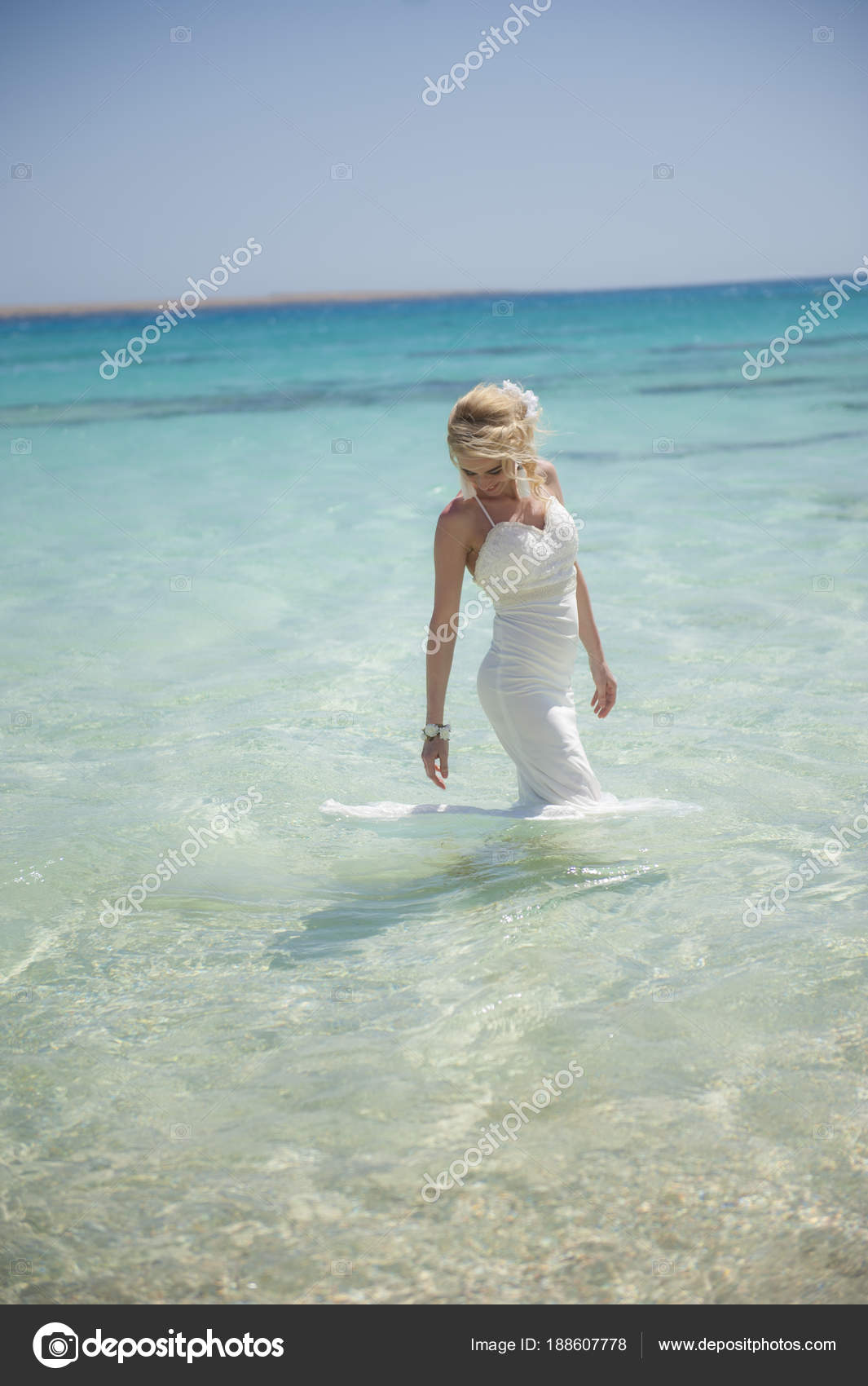 Beautiful bride in water on a tropical beach wedding day