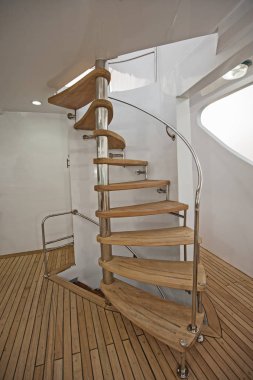 Wooden curved sprial staircase on sundeck of luxury yacht clipart