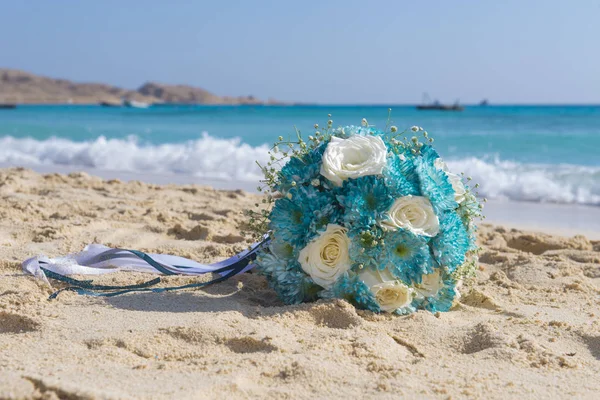 Bukett gäng blommor på en tropisk sandstrand — Stockfoto