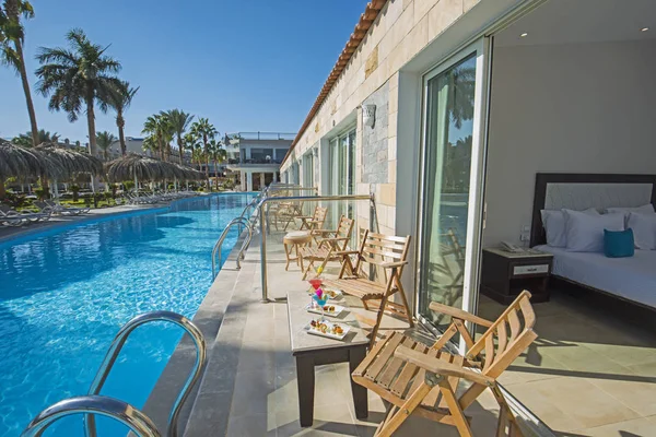 Bebidas de cóctel en la mesa junto a una piscina de lujo hotel reso —  Fotos de Stock