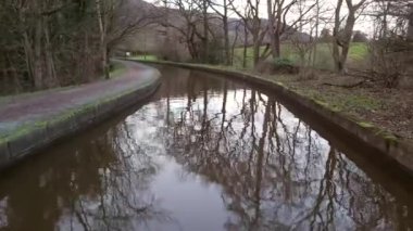 İngiliz ağaç kaplı su yolu kanalı üzerinde İngiliz kırsal kırsal sahne ile seyahat dar tekne yay görünümü