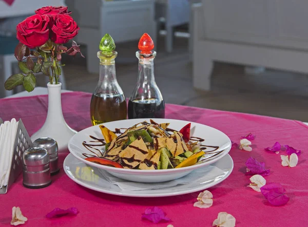 墨西哥玉米片色拉味道鲜美在餐馆里用酱汁和紫色桌布在白盘上点菜 — 图库照片
