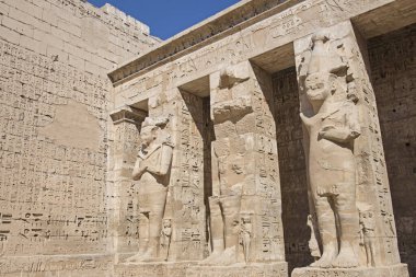 Antik Mısır 'ın Luxor' daki Medinat Habu tapınağının duvarına heykel ve hiyeroglif oymalar