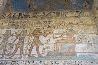 Luxor 'daki antik Mısır tapınağı Medinat Habu' nun duvarına çizilmiş hiyeroglif resimler.