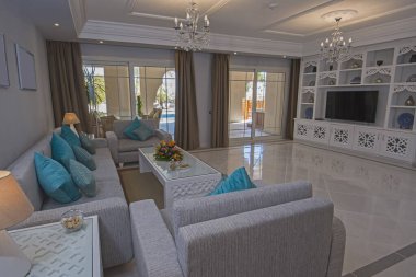 Lüks tatil köşkündeki oturma odası iç dekorasyon mobilya ve açık hava teraslarını gösteren evi gösteriyor.