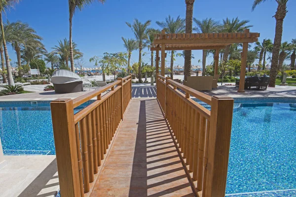 位于豪华热带酒店度假村露台的日光浴室 由木桥游泳池组成 — 图库照片