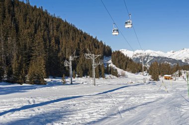 Dağ yamacında teleferikli bir kayak pisti manzarası