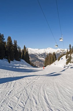 Dağ yamacında teleferikli bir kayak pisti manzarası